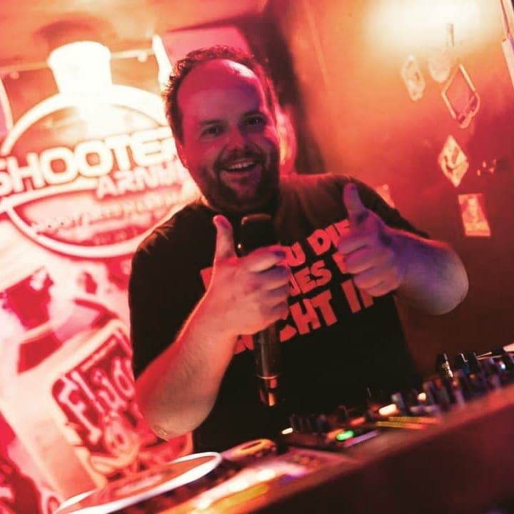 DJ Markza in actie achter de DJ booth tijdens een energiek optreden